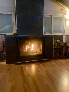 a fireplace in a living room with a fire in it at Casa abuhardillada con piscina y chimenea in Nívar