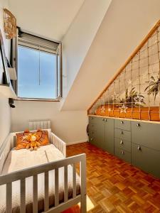 ブシー・サン ・ジョルジュにあるEscale family, Disneyland et Gare RER A à 7 minのベビーベッドと大きな窓付きのベッドルーム1室