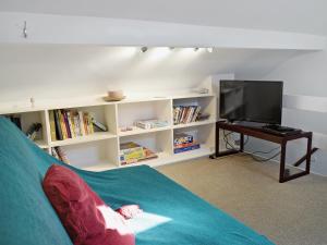 a living room with a couch and a television at Rose Cottage in Low Bradley +3 photos