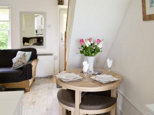 a living room with a table with flowers on it at Shore Cottage in Carsluith