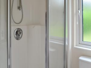 a shower with a glass door in a bathroom at Wye Lodge in Aberedw +7 photos