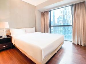 a large white bed in a room with a large window at Hesheng Hotel Apartment in Shenzhen +15 photos
