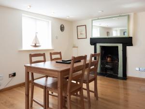 ein Esszimmer mit Tisch und Stühlen und einem Kamin in der Unterkunft Nelson Steps 3 in Kingswear