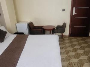a hotel room with a bed and a table and chairs at South gate hotel in Addis Ababa