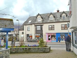 a man standing on a sidewalk in front of a building at Herdwick Heights in Keswick +2 photos