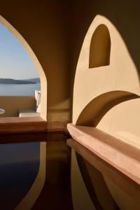 Zimmer mit Meerblick durch ein Fenster in der Unterkunft THE A COLLECTION by K&K in Oia + 136 Fotos