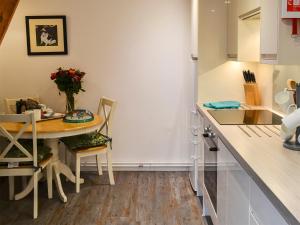 a kitchen with a table and chairs and a counter at Myrtle Loft in Instow