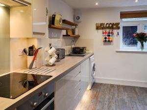 a kitchen with white cabinets and a counter top at Myrtle Loft in Instow