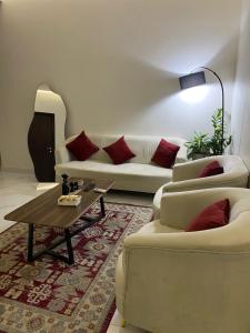 a living room with two couches and a coffee table at شقق المصيف الفندقيه in Hafr Al Baten +4 photos