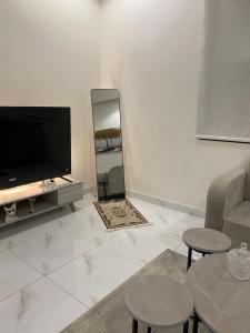 a living room with a television and a mirror at شقق المصيف الفندقيه in Hafr Al Baten