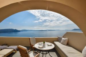 a room with a table and a view of the water at THE A COLLECTION by K&K in Oia