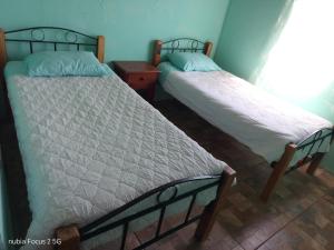 Dos camas una al lado de la otra en una habitación. en Blue Tavern House, en Vallenar