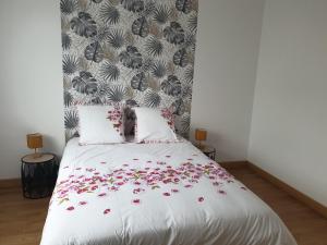 a bedroom with a white bed with red flowers on it at Logis Coeur de Bretagne in Bieuzy-les Eaux