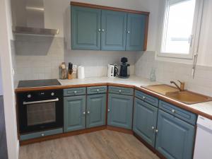 a kitchen with blue cabinets and a sink at Logis Coeur de Bretagne in Bieuzy-les Eaux