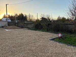 a gravel parking lot with a street sign on it at Appt RDC meublé 2 ou 4 pers in Blagny