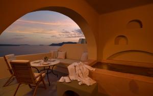 ein Wohnzimmer mit Sofa und Tisch in der Unterkunft THE A COLLECTION by K&K in Oia