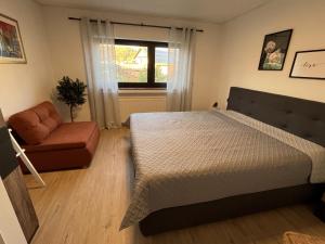 a bedroom with a bed and a couch and a window at EifelSeensucht in Heimbach +19 photos