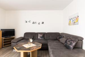 a living room with a brown couch and a coffee table at Inselglück App 2 in Norderney