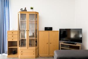 a living room with a tv and a wooden cabinet at Inselglück App 2 in Norderney