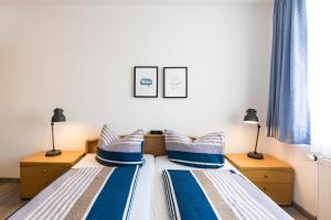 two beds with blue and white pillows in a bedroom at Inselglück App 2 in Norderney