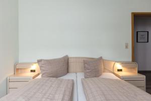 two beds in a room with two lamps on them at Mayglück App 1 in Norderney