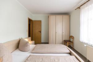 a bedroom with a white bed and a window at Mayglück App 1 in Norderney