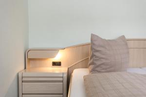 a small bedroom with a bed and a night stand at Mayglück App 1 in Norderney +9 photos
