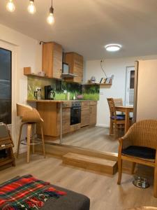 a kitchen with wooden cabinets and a table with chairs at Fewo Paul in Glowe