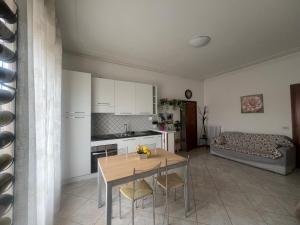 a kitchen and living room with a table and a couch at Casa di Isma in San Quirico dʼOrcia