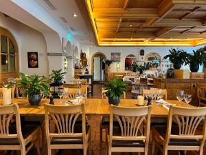 a restaurant with a large wooden table and chairs at Studio Top im des Alpes in Flims