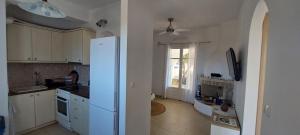 a kitchen with a white refrigerator and a window at Gio st Gio apartment 1 Antiparos st.Giorgio in Andiparos +32 photos