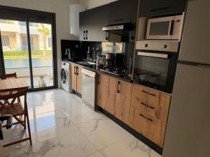 Kuchyň nebo kuchyňský kout v ubytování Superbe appartement 120 mc, Plage à pieds, 3 piscines & calme garanti - Sidi Rahal Plage