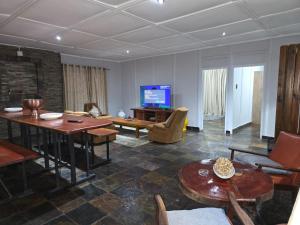 a living room with a table and a tv at Nandoni Maritime Home in Thohoyandou