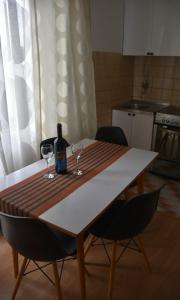 a table with two glasses and a bottle of wine at Monika in Široki Brijeg