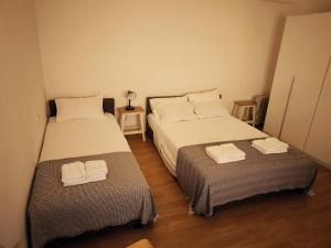 two beds in a small room with towels on them at Monika in Široki Brijeg