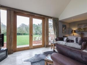 un salon avec un canapé et des portes coulissantes en verre dans l'établissement Lily Pad Lodge, à Donington on Bain