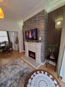 een woonkamer met een open haard en een tv erboven bij Relaxing House in Hull