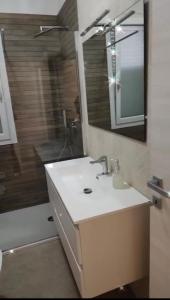 a bathroom with a sink and a shower with a mirror at Casa Via Marconi in Assemini