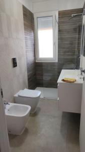 a bathroom with a toilet and a sink and a shower at Casa Via Marconi in Assemini