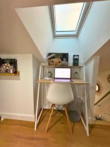 - Escritorio con ordenador portátil y silla en el ático en La Bulle Secrète, en Villeneuve-sur-Lot