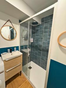 Un baño con ducha de cristal y lavabo. en La Bulle Secrète, en Villeneuve-sur-Lot