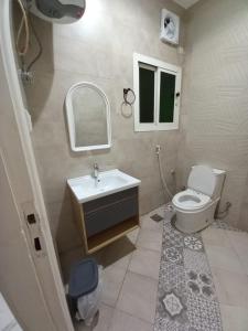 a bathroom with a toilet and a sink and a mirror at مركز السراج للوحدات المخدومة in Jeddah +83 photos