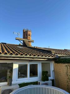 a house with a clock tower on the roof at La Bulle Secrète in Villeneuve-sur-Lot