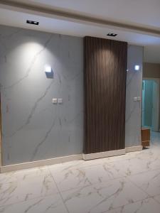 a lobby with a large marble wall with a column at مركز السراج للوحدات المخدومة in Jeddah