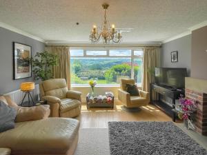 a living room with a couch and chairs and a television at Keepsake View in Two Dales