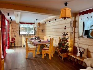 a dining room with a table and a christmas tree at Świstakówka in Szczyrk