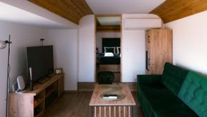 a living room with a green couch and a table at Magiczny Widok Tiny House in Jurków