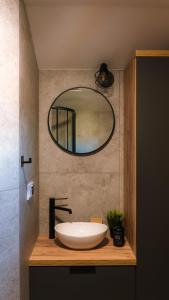 a bathroom with a sink and a mirror at Magiczny Widok Tiny House in Jurków