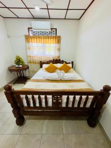 卡图纳耶克The Travellers Rest的一间卧室配有一张带黄色枕头的木床