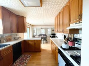 a kitchen with wooden cabinets and a dining room at Cozy Creek House in Forestburgh